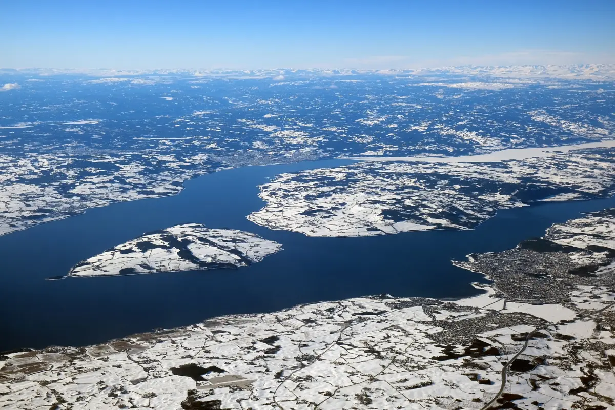 Flyfoto av Mjøsa med snødekte øyer og bredder om vinteren